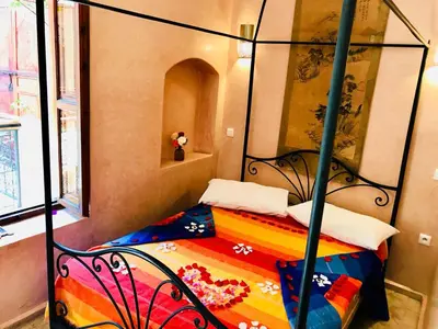 a bedroom with a bunk bed with a colorful blanket at Riad AKL in Marrakech