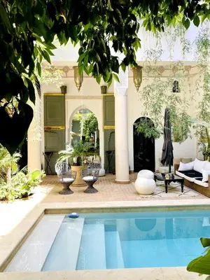 a house with a swimming pool in a yard at Riad Rafaele & SPA in Marrakech