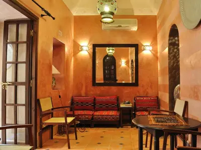 a waiting room with chairs and tables and a mirror at Riad Marrakiss in Marrakech