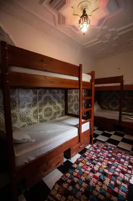 two bunk beds in a room with a checkered floor at Mosaic Hostel in Marrakech