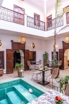 a pool in the middle of a room with a table and chairs at Riad Dar Elma And Spa in Marrakech