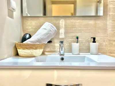 a bathroom sink with a towel and a basket on it at Marrakech golf City prestigia in Marrakech