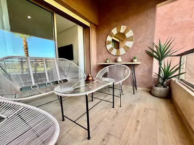 a dining room with two chairs and a glass table at Marrakech golf City prestigia in Marrakech