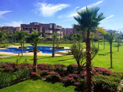 a view of a resort with palm trees and a pool at Marrakech golf City prestigia in Marrakech