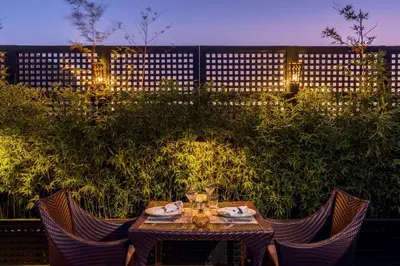 a table with chairs in a garden with lights at Riad Idra in Marrakech