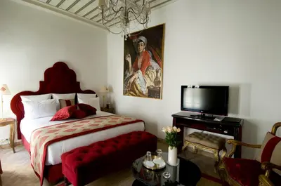 a bedroom with a large bed and a tv at Riad Idra in Marrakech