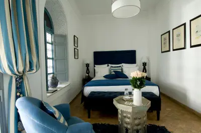 a bedroom with a bed and a table and chairs at Riad Idra in Marrakech
