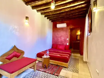 a living room with a red couch and a chair at Riad Prada in Marrakech