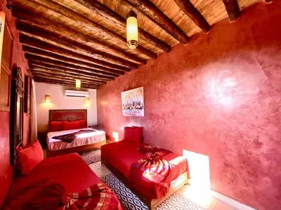 a bedroom with two beds and a couch in a room at Riad Prada in Marrakech
