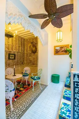 a room with a table and chairs and a ceiling fan at Riad Tibibt in Marrakech