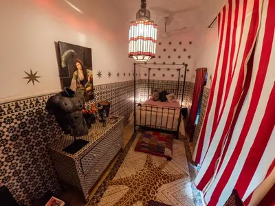 a room with a bed and an american flag at Riad Tibibt in Marrakech