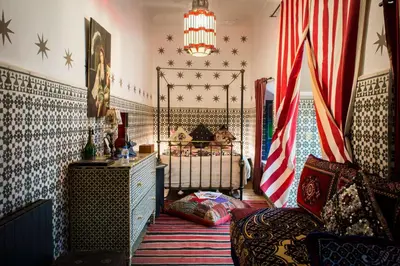 a bedroom with a bed with an american flag at Riad Tibibt in Marrakech