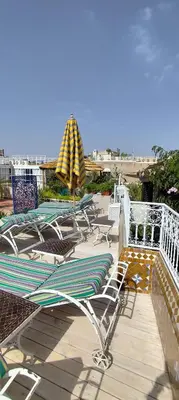 a group of chairs and umbrellas on a deck at Riad Dar Saad - Hammam & Spa in Marrakech