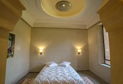 a bedroom with a white bed with a ceiling at Villa Berbère Domaine des Kasbahs in Marrakech