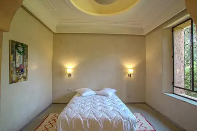 a bedroom with a bed in the corner of a room at Villa Berbère Domaine des Kasbahs in Marrakech