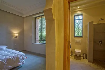 a bedroom with a bed and a window and a toilet at Villa Berbère Domaine des Kasbahs in Marrakech