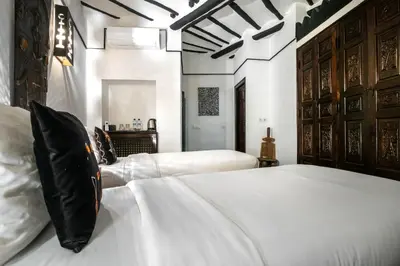 a bedroom with two beds with white sheets and wooden headboards at Dar Alhambra Riad Medina in Marrakech