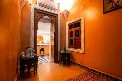 a hallway with two tables and an open door at Dar Alhambra Riad Medina in Marrakech