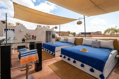 a patio with two beds and a kitchen on a balcony at Dar Alhambra Riad Medina in Marrakech
