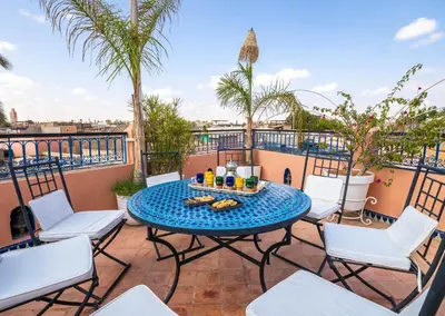 a patio with a table and chairs on a balcony at Dar Alhambra Riad Medina in Marrakech