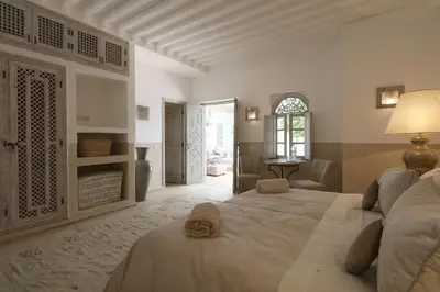 a bedroom with two beds and a living room at Medina Dream Riad Exclusive Rental in Marrakech