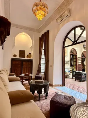 a living room with couches and a chandelier at Riad Djemanna in Marrakech