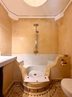 a bathroom with a bath tub and a toilet at Riad Djemanna in Marrakech