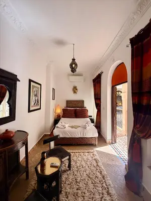 a bedroom with a bed and a table at Riad Djemanna in Marrakech