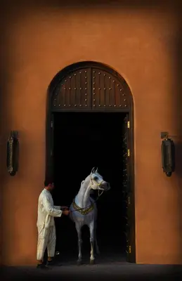 a man standing next to a statue of a horse at Selman Marrakech in Marrakech