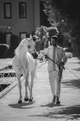 a man walking a white horse on a leash at Selman Marrakech in Marrakech