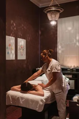 a woman making a woman lie on a bed at Selman Marrakech in Marrakech