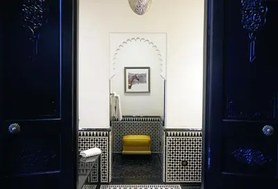 a bathroom with a yellow chair in a room at Selman Marrakech in Marrakech