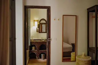 a bathroom with a mirror and a sink and a bed at Outsite Marrakesh in Marrakech