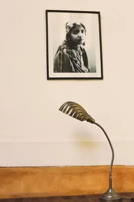 a lamp sitting on a table with a picture on the wall at Riad Laila in Marrakech