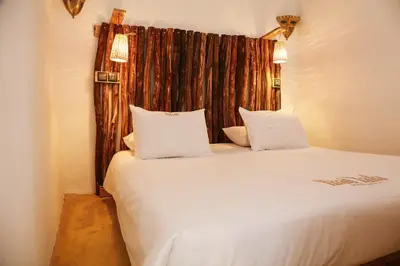 a bedroom with a bed with white sheets and pillows at Riad Laila in Marrakech