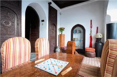 a dining room with a wooden table and chairs at Riad Ben Tachfine in Marrakech