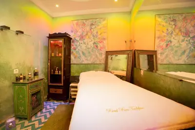 a bedroom with a bed and a bathroom with colorful walls at Riad Ben Tachfine in Marrakech