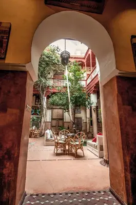 an archway with a table and chairs in front of a building at Riad Chorfa in Marrakech