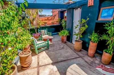 a patio with potted plants and a table and chairs at Riad Chorfa in Marrakech