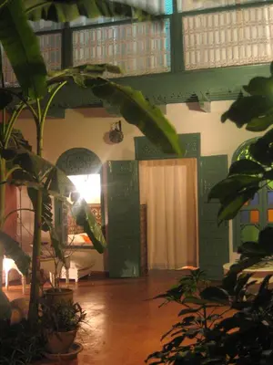 a living room with plants and a room with a table at Riad Dar Mchicha in Marrakech