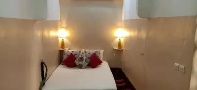 a small room with a bed with two lights on it at Riad Dar Mchicha in Marrakech