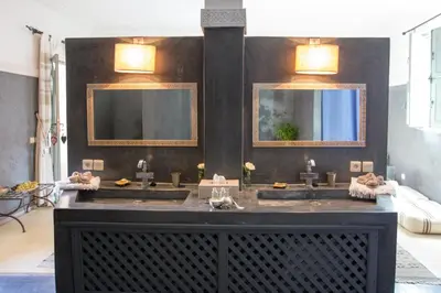 a bathroom with two sinks and two mirrors at Riad Olema et Spa in Marrakech