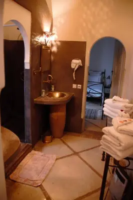 a bathroom with a sink and a mirror in a room at Riad Dar El Gnaouia in Marrakech