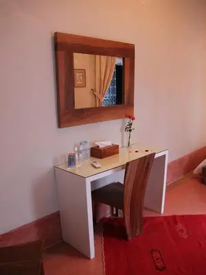 a desk in a room with a mirror on the wall at Riad Dar El Gnaouia in Marrakech