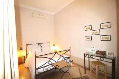 a bedroom with a bed and a desk in it at Riad Dar El Gnaouia in Marrakech