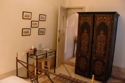 a room with a large wooden cabinet and a table at Riad Dar El Gnaouia in Marrakech