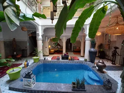 a large indoor pool in a building with plants at Riad Eloise in Marrakech