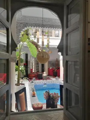a view of a swimming pool through a window at Riad Eloise in Marrakech