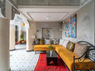 a living room with a yellow couch and a red rug at Riad Eloise in Marrakech