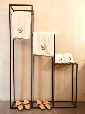 a towel rack with two towels and two pairs of shoes at Riad Abracadabra in Marrakech